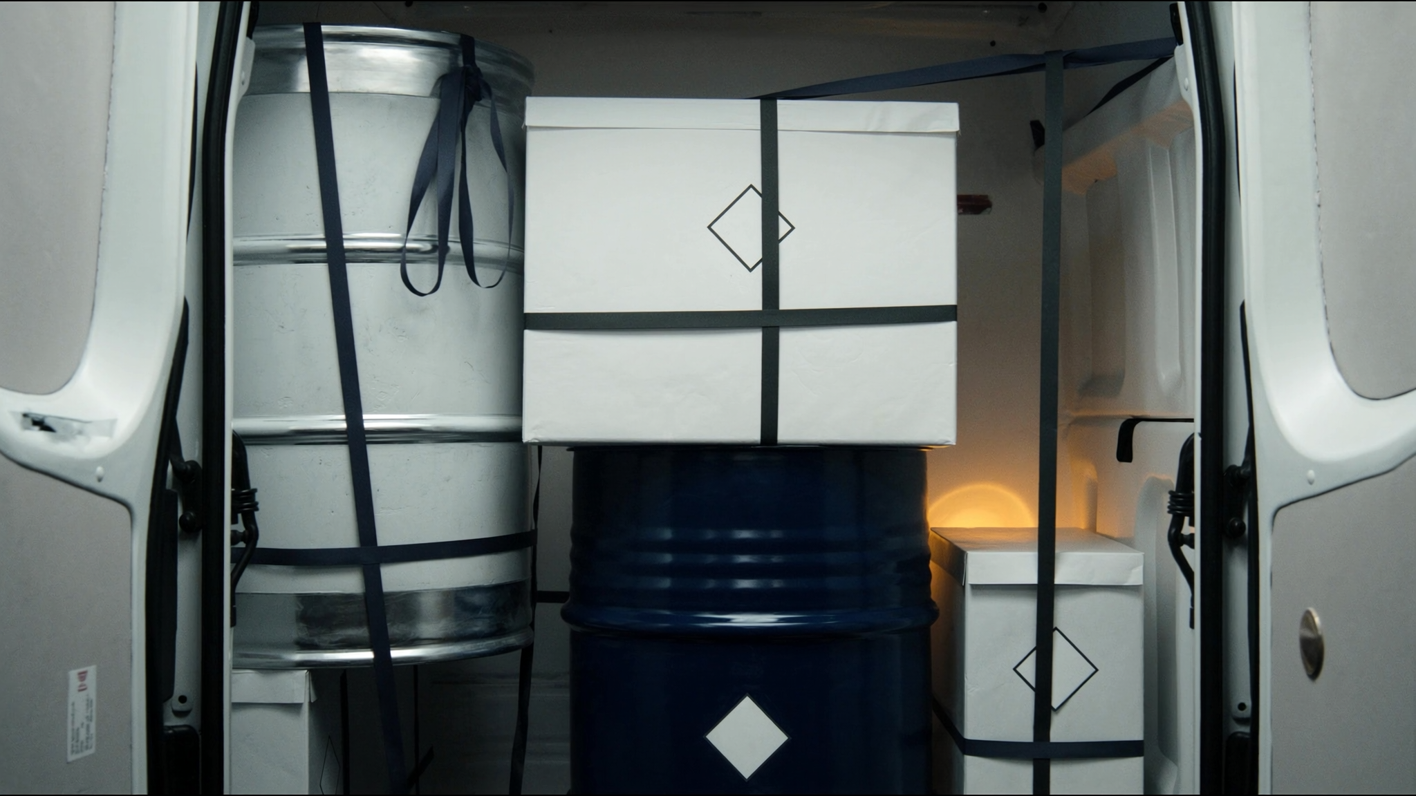 Drums and boxes secured with straps inside an Isospeed7 vehicle cargo area