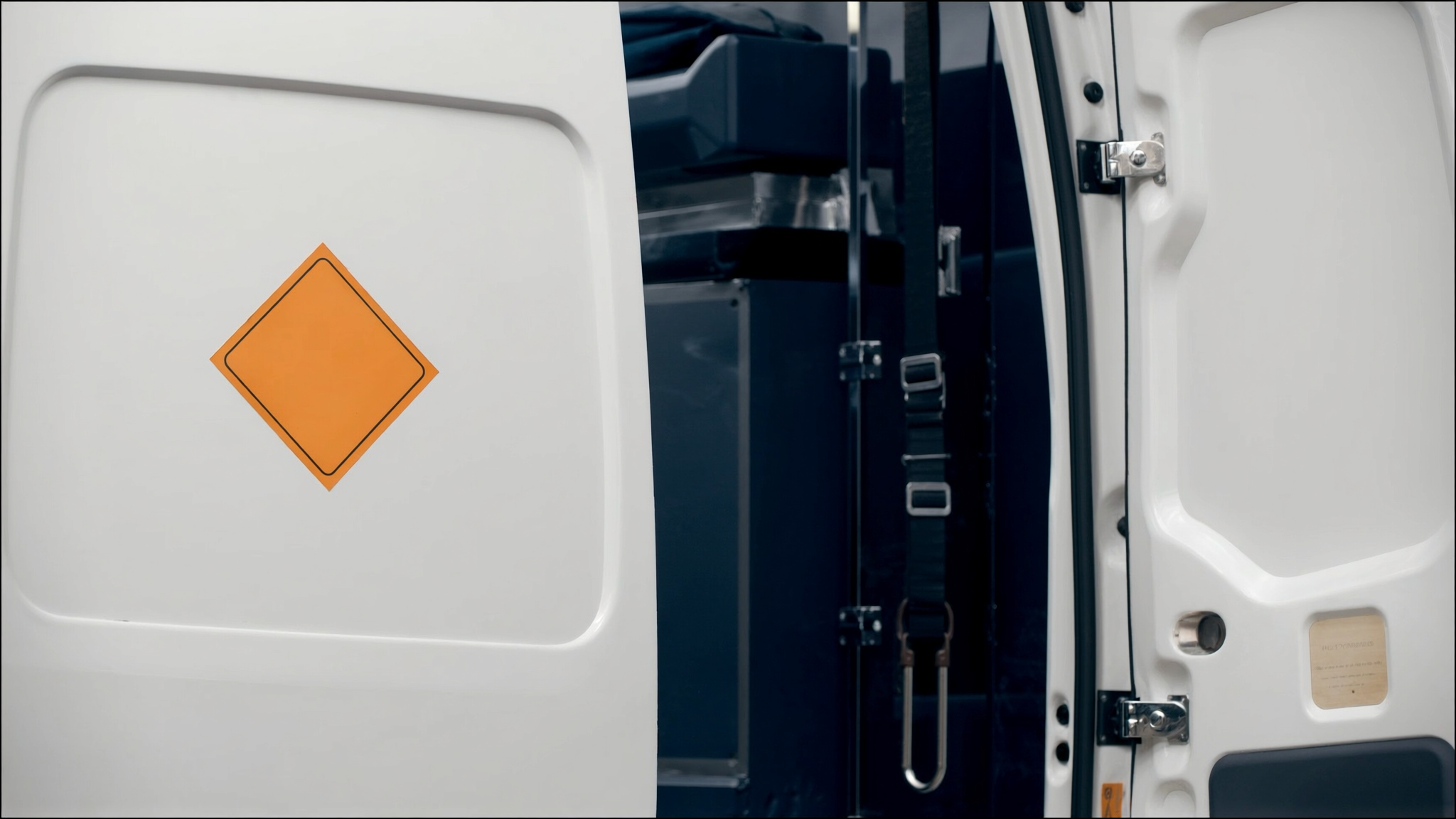 Professional detail of hazard placarding and secure equipment on a commercial vehicle